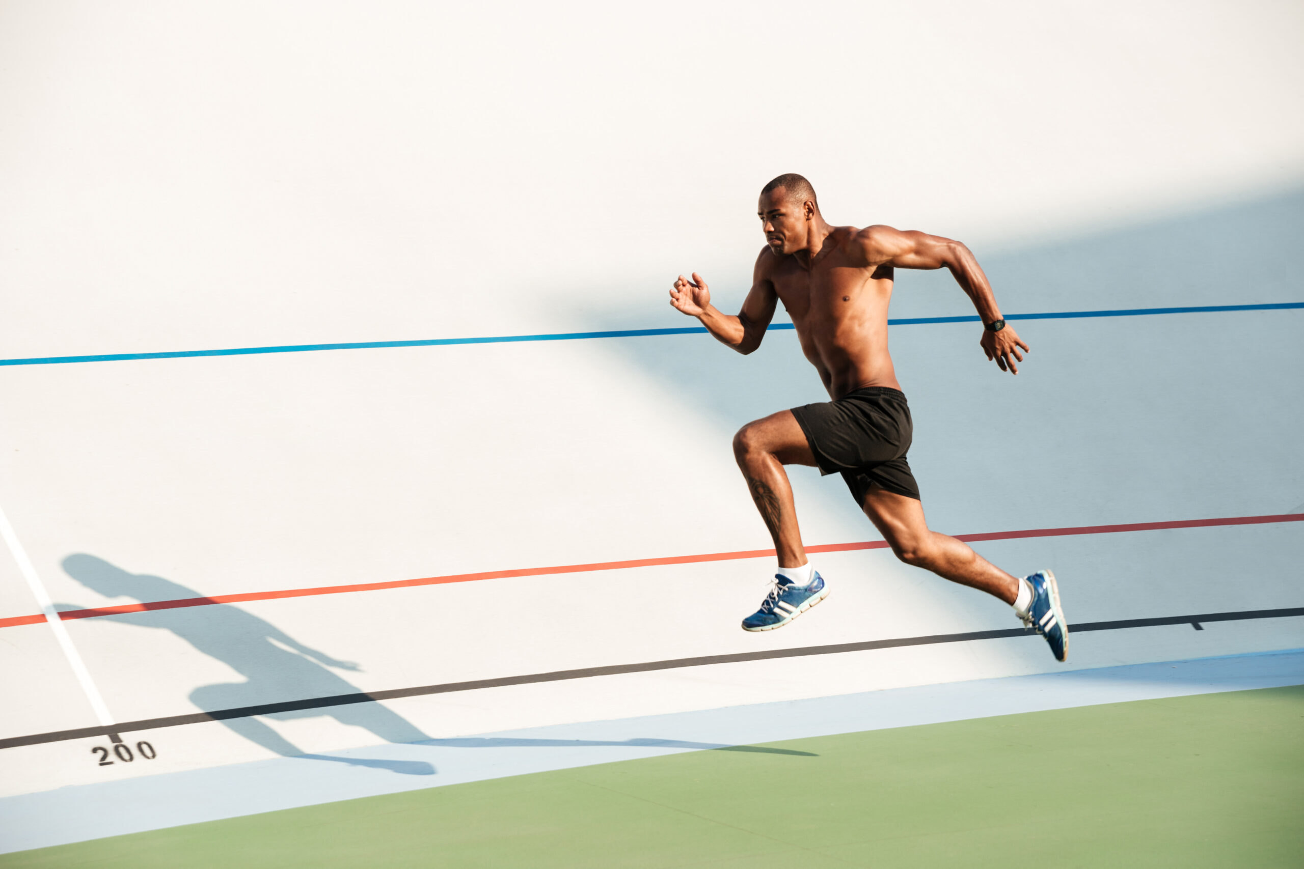 Runner sprinting across a bright track